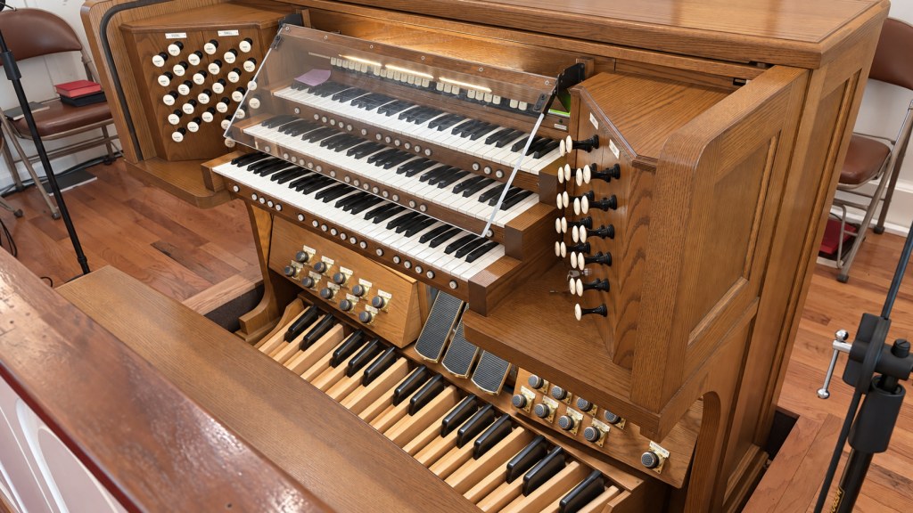 The church's wooden organ console with three keyboards, stop knobs, and pedalboard